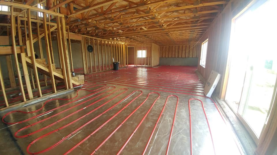 A room with wood floors and red pipes